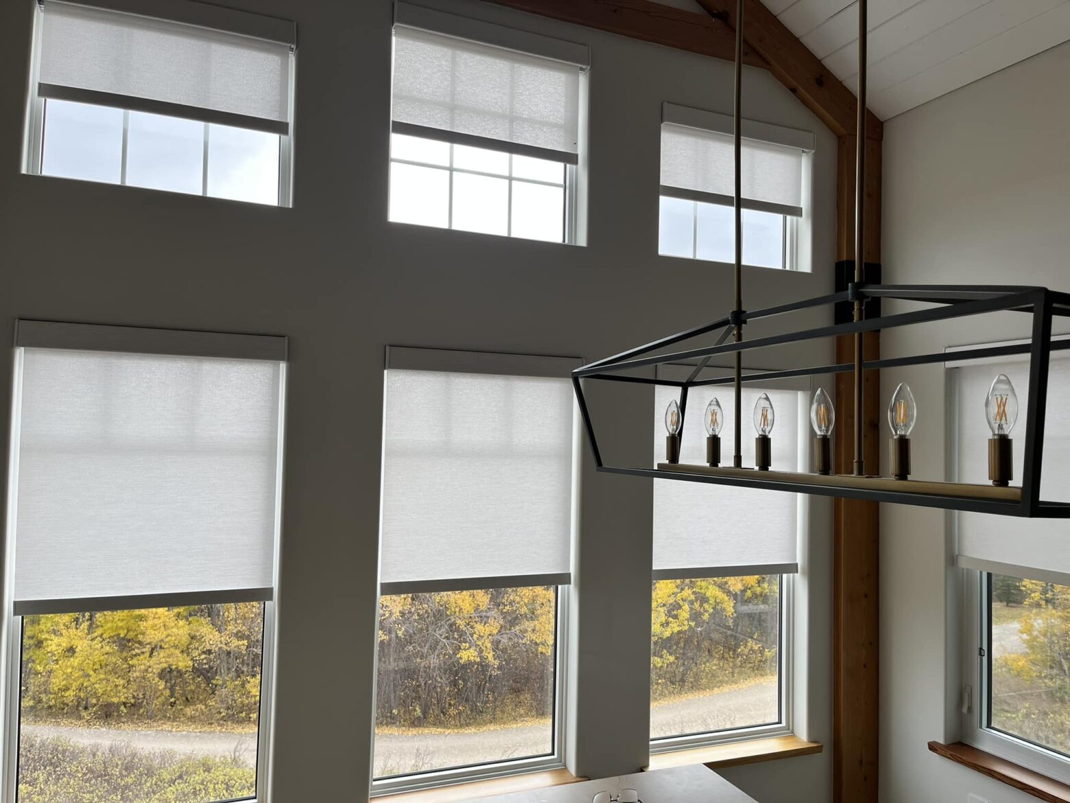 Automated shades applied to six different windows in a dining room setting.