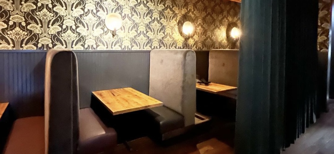 A row of dining booths in a restaurant. A drape covers one of the booths.